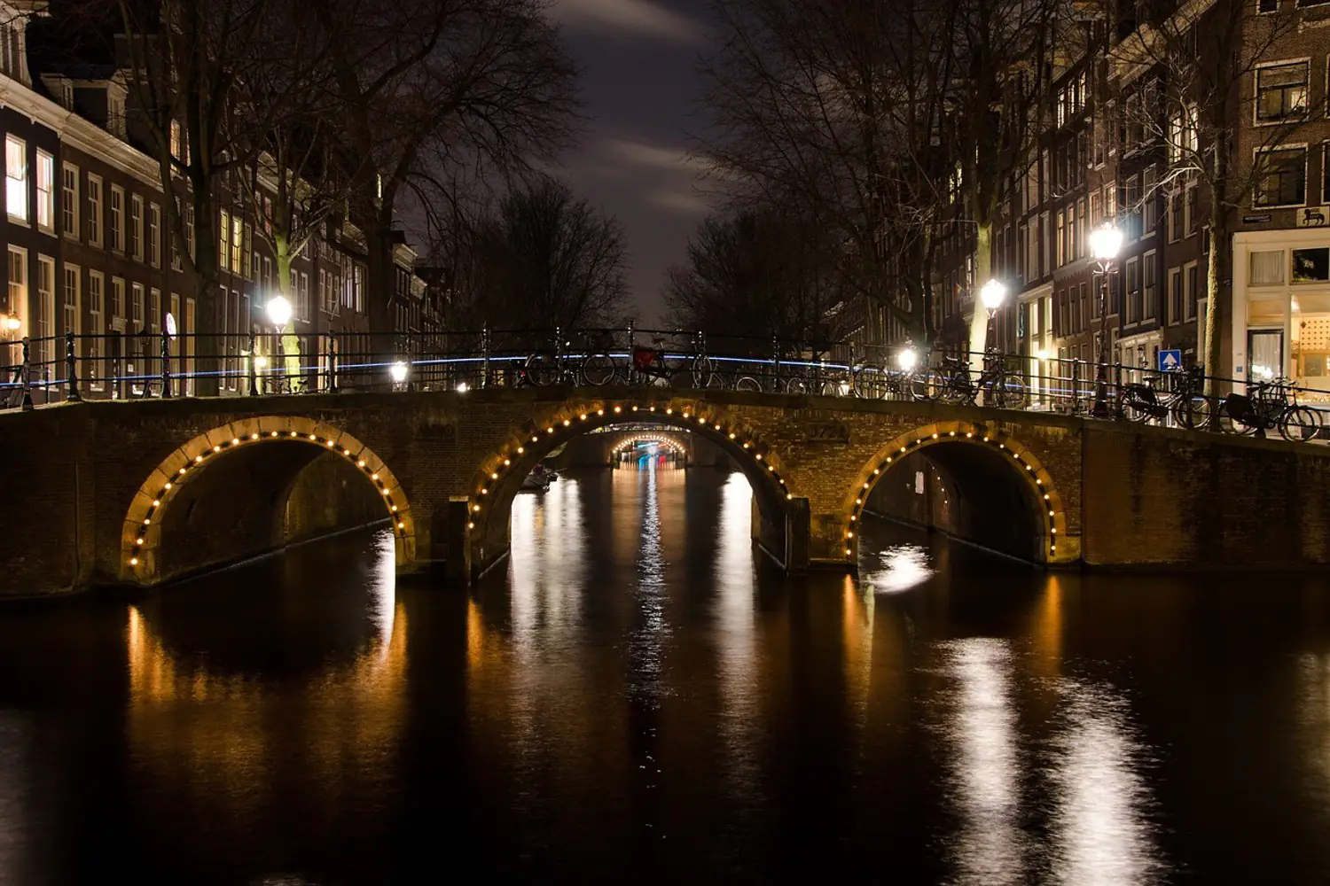 Fototapet At night in Amsterdam